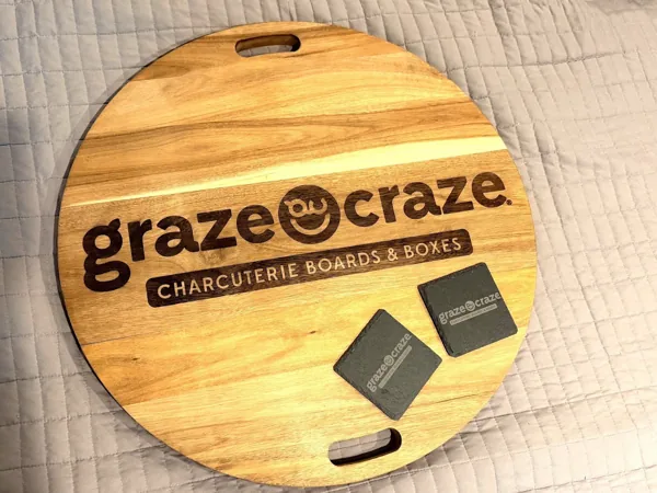 Graze Craze engraved wooden serving board with two branded slate coasters.